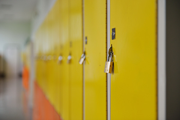 side view of a school hallway of yellow lockers