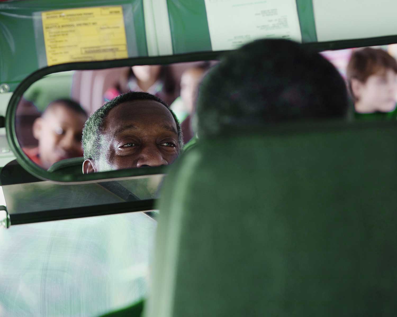 Bus driving looking in rear view mirror