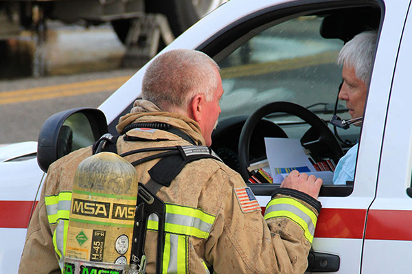 Members of a fire and ems crew talking through the window of an emergency vehicle